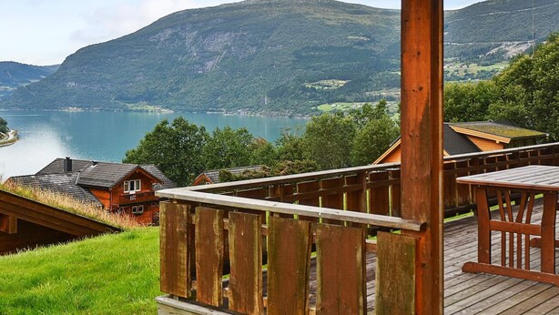 A wooden deck with a view of a lake and mountains. - 4 Person Holiday Home in Olden (Stryn)