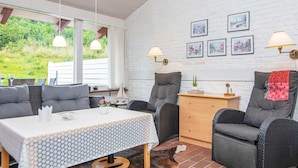 Une pièce chaleureuse avec une table, des chaises, un canapé, une lampe et un tapis en peau de vache.