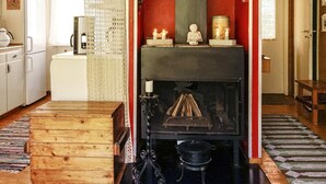 Una cocina acogedora con chimenea, suelo de madera y una pared de acento roja.