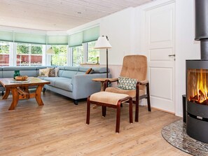A cozy living room with a sofa, armchair, and a fireplace. - Vibrant Holiday Home in Tarm near Sea (Hemmet)