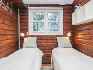 A cabin with two beds, a window with a view of trees, and a white shelf above the window. - Vibrant Holiday Home in Jutland near Sea (Glesborg)