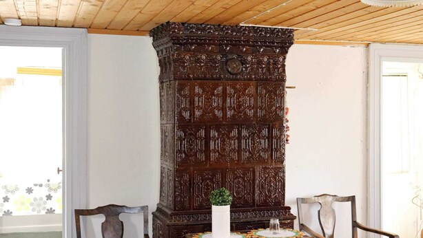 A room with a wooden cabinet, two chairs, a small table, and a radiator. - 6 Person Holiday Home in Kyrkhult (Kyrkhult)