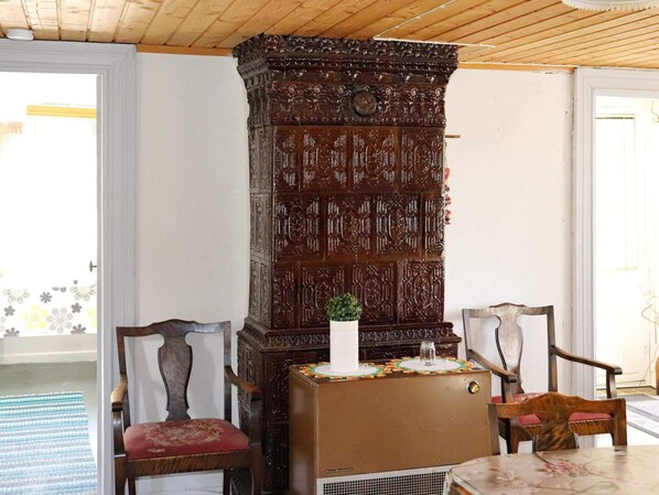 A room with a wooden cabinet, two chairs, a small table, and a radiator. - 6 Person Holiday Home in Kyrkhult (Kyrkhult)