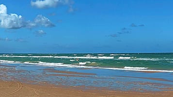Una playa con cielos despejados y olas.
