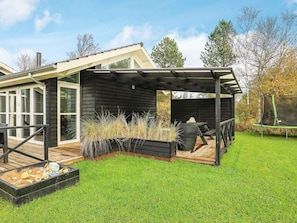 A modern house with a covered patio, a deck, and a trampoline. - 5 Star Holiday Home in Jerup (Jerup)