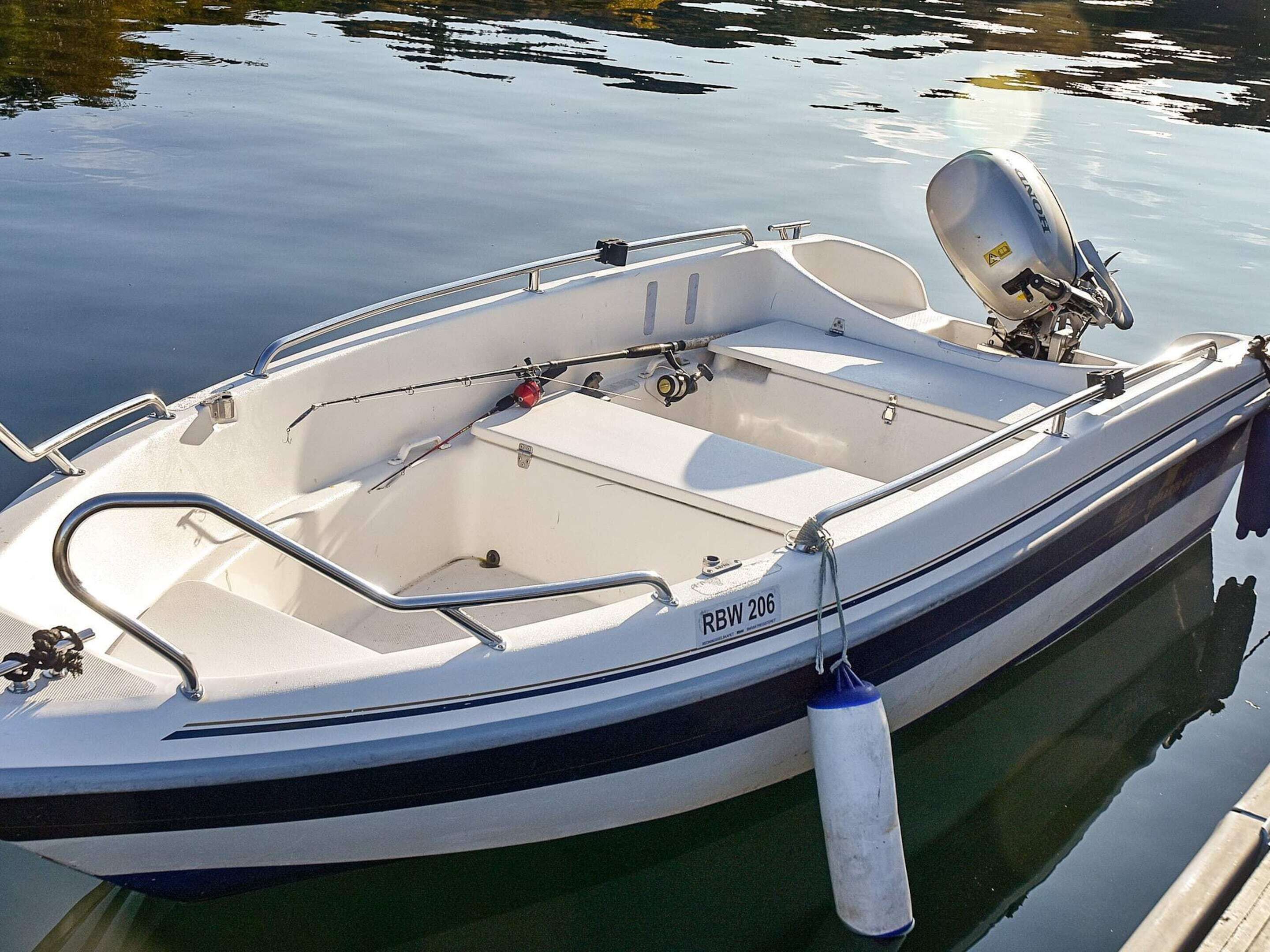 A small motorboat with a cabin, equipped with a motor, and a registration number RBW 206.