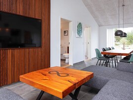 Un interior moderno con una mesa de madera, un sofá y un comedor.