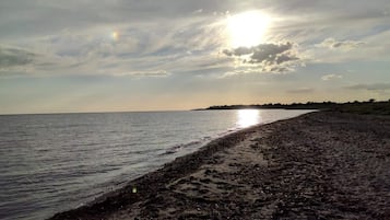 Ein Strand mit breitem Sandstrand und ruhigem Wasser.
