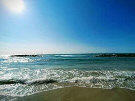 Una playa con olas y cielo despejado.