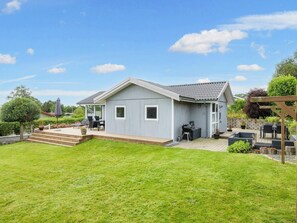 A single-story house with a covered patio, a barbecue area, and a small deck.