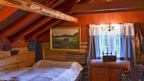A rustic wooden room with a bed, a dresser, a painting, and a window with curtains. - 3 Person Holiday Home in Bofjorden (Surnadal)