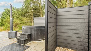 Et spabad med træhegn, sauna og pergola.