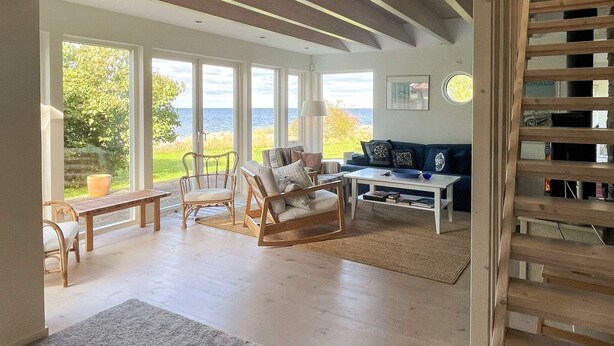 Un salon spacieux doté d’une grande fenêtre offrant une vue panoramique, d’une table basse en bois et d’un coin salon confortable.