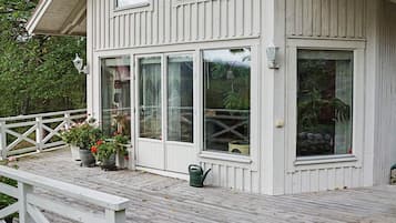 A white wooden house with large windows and a covered porch.
