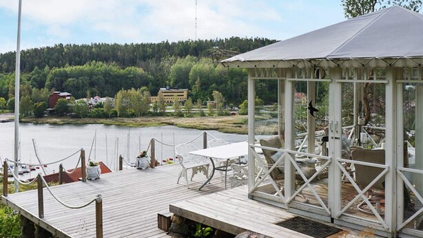 Eine Holzsteg mit einem Pavillon, einem Tisch und Stühlen.