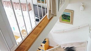 Eine Holztreppe mit weißer Handlauf und einem schwarz-weißen Teppich.
