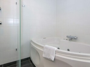 A modern bathroom with a freestanding bathtub, a glass shower enclosure, and white tiled walls. - 5 Star Holiday Home in Ebeltoft (Ebeltoft)