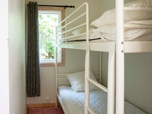 A bunk bed with white bedding and a window with a curtain. - 4 Person Holiday Home in Smedstorp (Smedstorp)