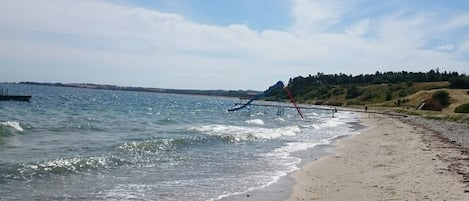 A beach with a water slide and a sandy shore.