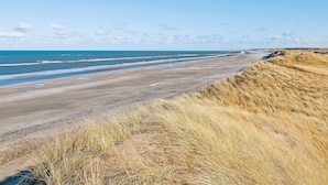 A beach with dunes and the ocean. - 5 Star Holiday Home in Hjorring (Hjørring)