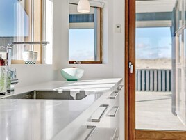Una cocina moderna con una isla grande, una ventana y vistas a la playa.