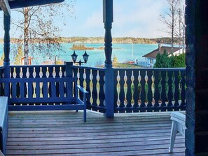A wooden deck with a railing, overlooking a body of water and distant land. - 4 Person Holiday Home in Soderkoping (Soderkoping)