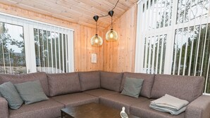 A modern living room with a sectional sofa, a coffee table, and two pendant lights. - Serene Holiday Home in Jutland near Sea (Thisted)