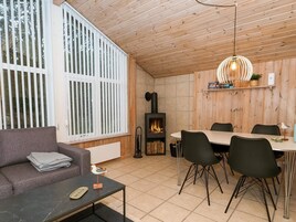 En hyggelig stue med pejs, spiseplads med stole, sofa og sofabord.