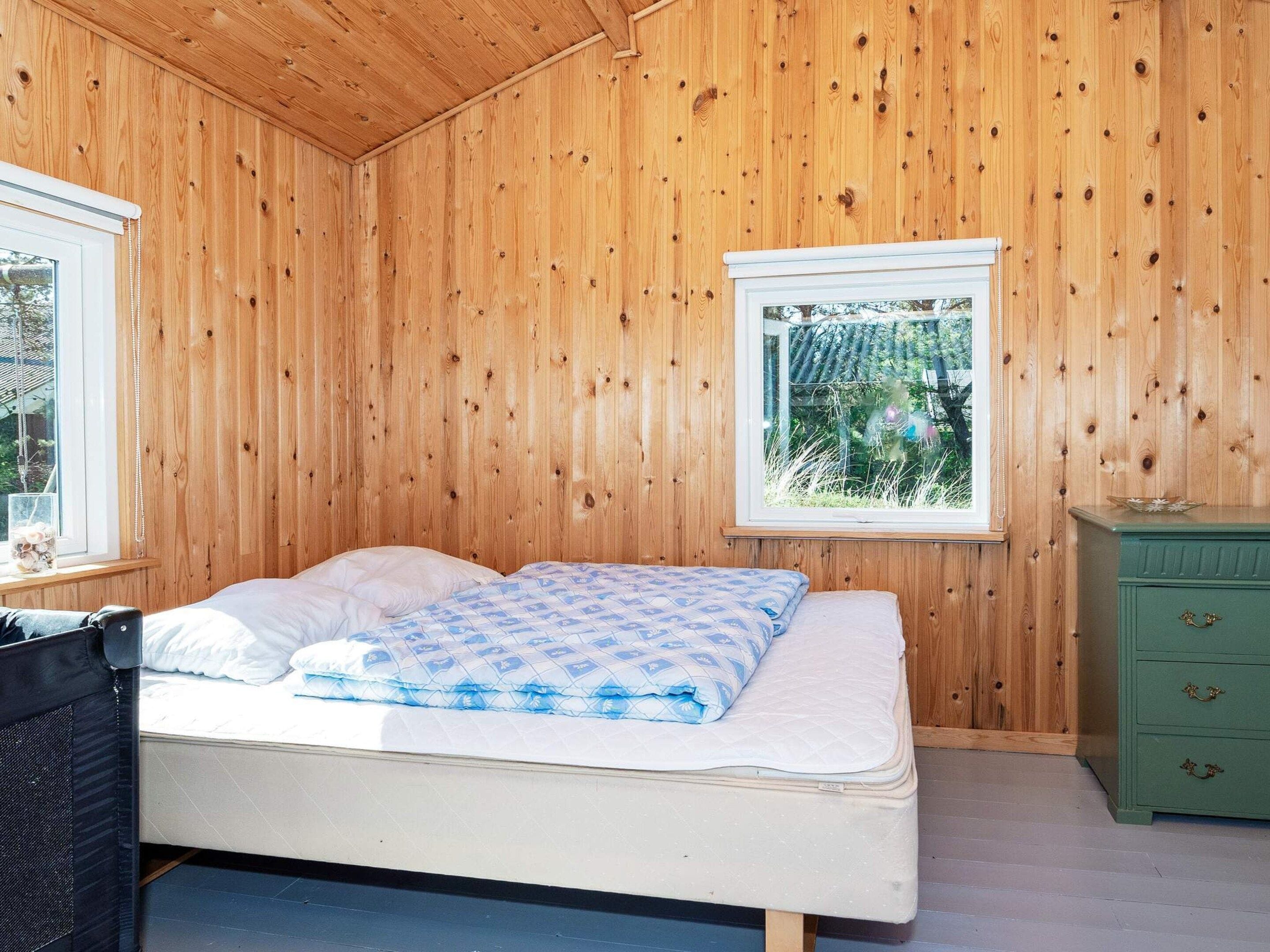 A room with a bed, a window, and a green dresser.
