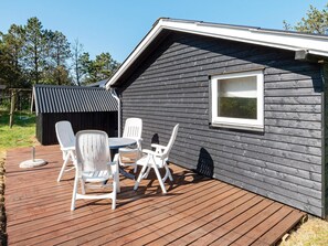 A deck with outdoor furniture and a small building with a window. - Serene Holiday Home in Jutland near Sea (Thisted)