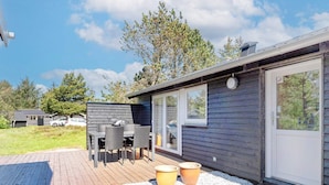 A modern cabin with a deck, outdoor seating, and a garage. - Serene Holiday Home in Jutland near Sea (Thisted)