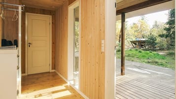 Een houten binnenhal die uitkomt op een terras met uitzicht op de omgeving.