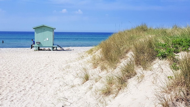 A beach with a light blue lifeguard hut and a clear blue sky. - 8 Person Holiday Home in Frederiksvaerk (Frederiksvaerk)