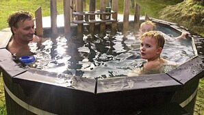 A hot tub with a wooden structure around it, surrounded by grass. - Spacious Holiday Home in Jutland With Outdoor Whirlpool (Pandrup)