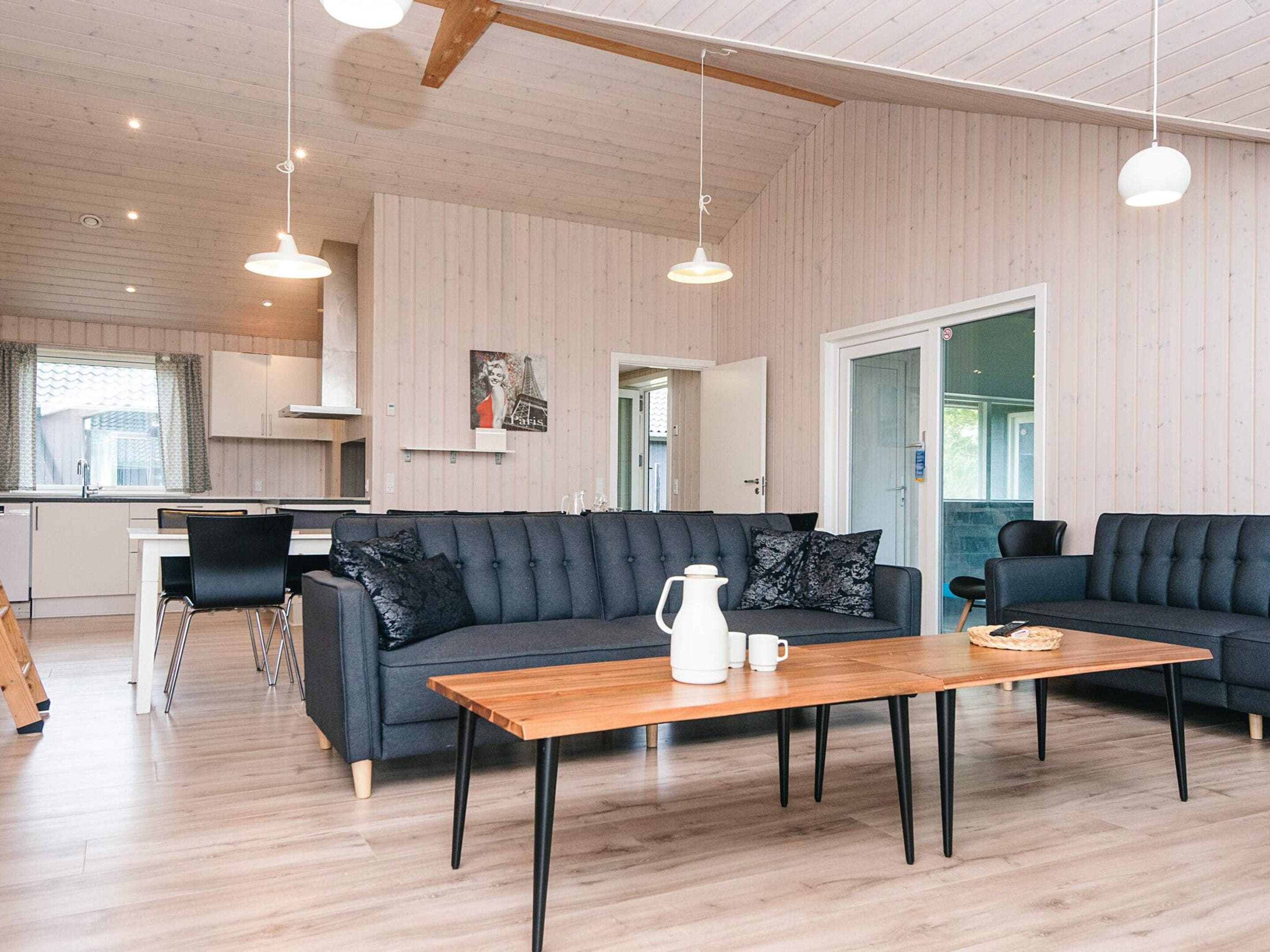 A modern living room with a sofa, a coffee table, and pendant lights.