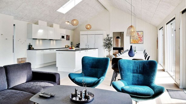 A modern living room with a sofa, a coffee table, and two blue armchairs. - 5 Star Holiday Home in Grenaa (Grenaa)