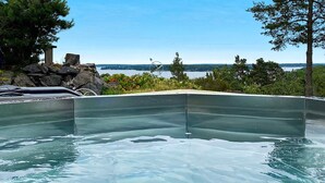 A swimming pool with a clear view of the lake and trees in the background. - 4 Star Holiday Home in Akersberga (Akersberga)