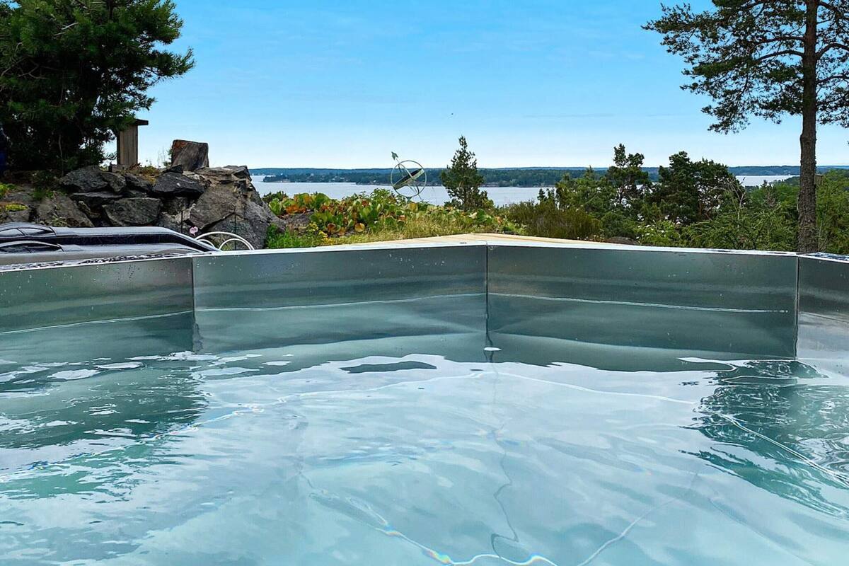 A swimming pool with a clear view of the lake and trees in the background.