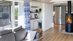 A modern living room with a grey sofa, a white coffee table, and a blue patterned curtain. - 4 Star Holiday Home in Akersberga (Akersberga)