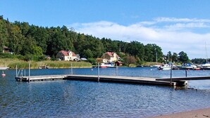 A calm waterfront with a dock extending into the water, surrounded by houses and boats. - 4 Star Holiday Home in Akersberga (Akersberga)