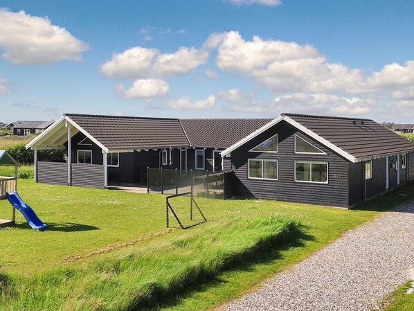 A row of modern, two-story cabins with a covered patio area and a playground.