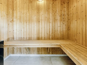 A sauna room with wooden walls and benches.