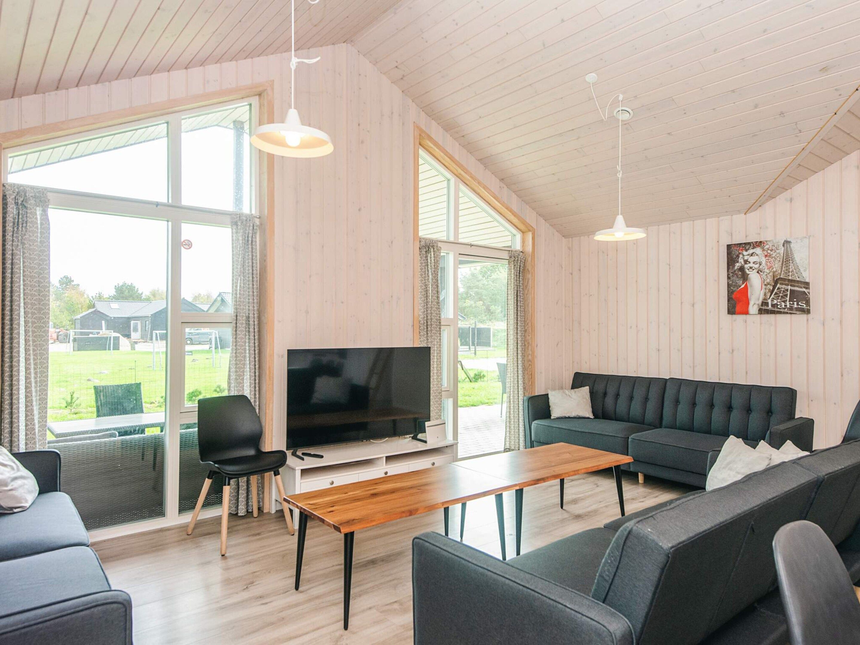 A modern living room with a television, sofa, and dining table.