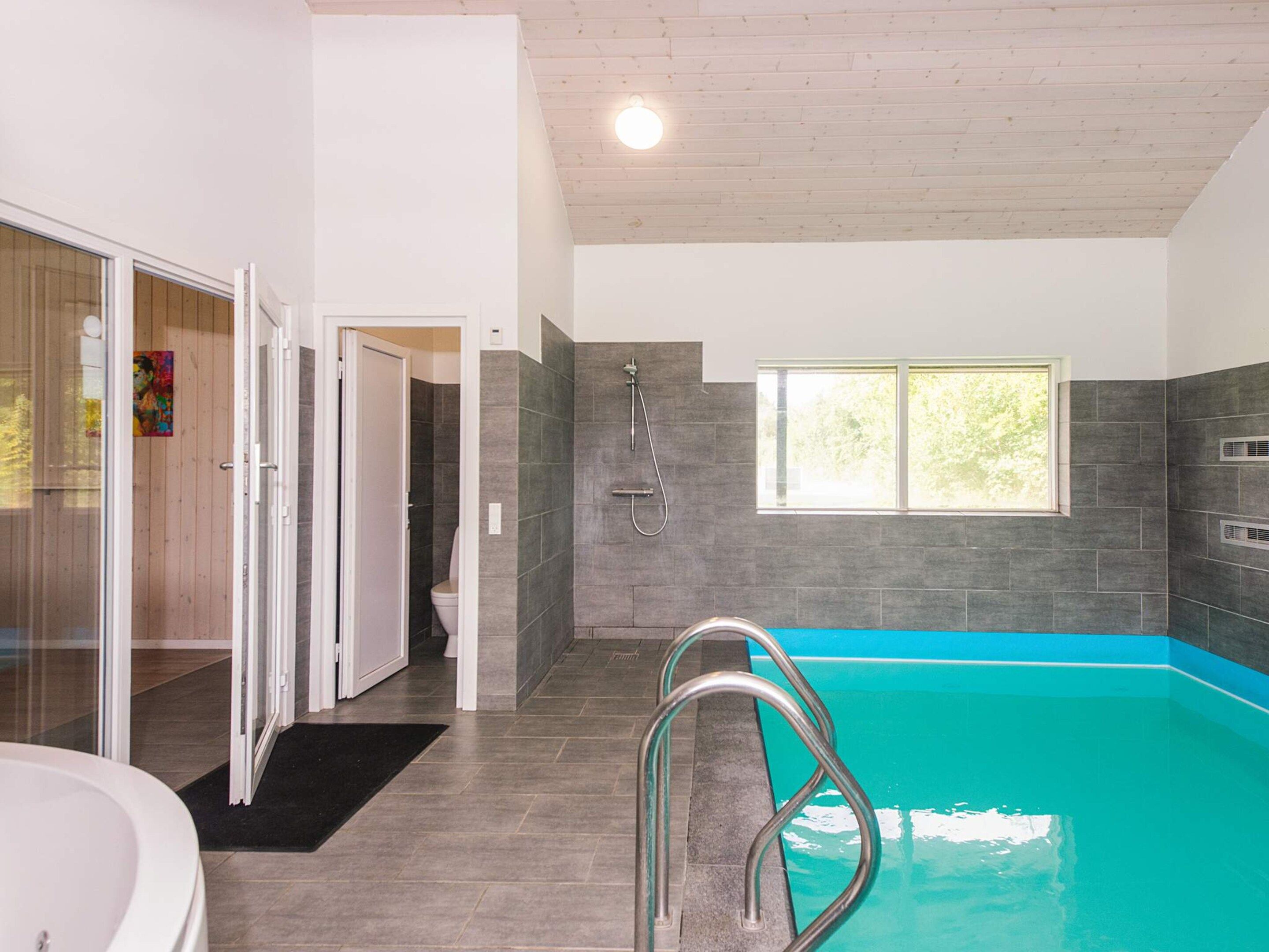 Un baño moderno con piscina integrada, ducha y retrete.