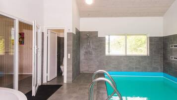 Un baño moderno con piscina integrada, ducha y retrete.