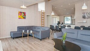 A modern living room with grey sofas, a black coffee table, and a wooden floor.