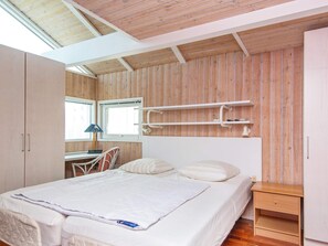 A bedroom with a bed, a desk, and a chair. - 4 Star Holiday Home in Ebeltoft (Ebeltoft)