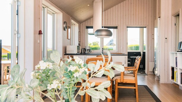 A modern interior with a dining area, kitchen, and large windows. - Alluring Holiday Home in Haderslev near Sea (Hejls)