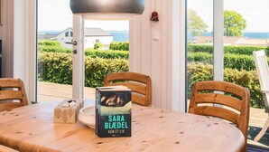 A wooden dining table with a book titled 'Sara Blædel' and a decorative box. - Alluring Holiday Home in Haderslev near Sea (Hejls)