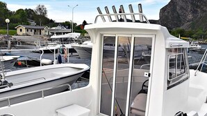 A boat with a cabin, a small deck area, and a motor at the stern.